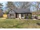 Renovated home with dark siding, updated landscaping, and natural shutters on the front windows at 5954 Crestview Ave, Indianapolis, IN 46220