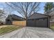 View of a newly constructed two-car garage and the main house, separated by a new wood fence and stone driveway at 5954 Crestview Ave, Indianapolis, IN 46220