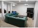 Spacious carpeted basement with a lounge area and large green leather couch at 5983 Clearview Dr, Carmel, IN 46033
