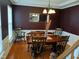 Formal dining room with hardwood floors, dark accent wall, and traditional chandelier at 5983 Clearview Dr, Carmel, IN 46033