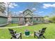 Well maintained backyard featuring a fire pit, Adirondack chairs, green lawn and home's exterior at 6185 Evanston Ave, Indianapolis, IN 46220
