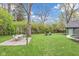 Spacious backyard features a patio set, lawn and green landscaping with a backyard house at 6185 Evanston Ave, Indianapolis, IN 46220