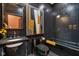 Modern bathroom features black tile, black fixtures, and an abstract art piece at 6185 Evanston Ave, Indianapolis, IN 46220