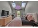 Bedroom featuring skylights, view of backyard, dresser and mounted television at 6185 Evanston Ave, Indianapolis, IN 46220