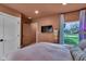 Bedroom with a pink bed, TV, and large window with a view of the yard at 6185 Evanston Ave, Indianapolis, IN 46220