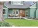 Inviting front porch with rocking chairs, complemented by a manicured lawn, and a view of the brick chimney at 6185 Evanston Ave, Indianapolis, IN 46220