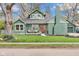 Charming green exterior view featuring well-kept lawn, inviting porch, and a view of the brick chimney and roof at 6185 Evanston Ave, Indianapolis, IN 46220