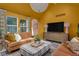 Bright living room with yellow walls, a TV, and comfortable seating at 6185 Evanston Ave, Indianapolis, IN 46220