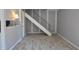 Spacious living area with wood-look flooring and staircase with black railings at 6512 Lupine Ter # 6512, Indianapolis, IN 46224