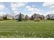 View of several homes from a large grassy common backyard surrounded by mature trees at 6645 Braemar N Ave, Noblesville, IN 46062
