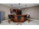 Finished basement bar with rich wood cabinetry, pendant lighting, and seating, perfect for entertaining guests at 6645 Braemar N Ave, Noblesville, IN 46062