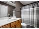 Neutral bathroom featuring a wood vanity, a white sink, a toilet, and a shower with a striped curtain at 6645 Braemar N Ave, Noblesville, IN 46062