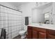 Bright bathroom featuring a wood vanity, a white sink, a toilet, and a shower with a striped curtain at 6645 Braemar N Ave, Noblesville, IN 46062
