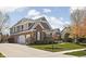 Elegant home featuring a three-car garage, brick accents, gray siding, and lush landscaping at 6645 Braemar N Ave, Noblesville, IN 46062