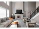 Comfortable living room featuring a fireplace, gray sofa, and natural light from large windows at 6645 Braemar N Ave, Noblesville, IN 46062