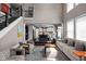 Open-concept living room with high ceilings, large windows, and view of the kitchen and staircase at 6645 Braemar N Ave, Noblesville, IN 46062