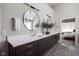 This beautifully designed main bathroom has double sinks and striking round mirrors above the vanity at 6645 Braemar N Ave, Noblesville, IN 46062