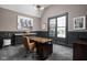 Stylish office with a vaulted ceiling, gray walls, large window, and a wood desk at 6645 Braemar N Ave, Noblesville, IN 46062