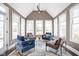 Bright sunroom with large windows, vaulted ceilings, and stylish seating arrangements at 6645 Braemar N Ave, Noblesville, IN 46062
