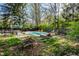 Spacious backyard featuring an in-ground pool, multiple seating areas, mature trees, and well-maintained landscaping at 6911 N Tuxedo St, Indianapolis, IN 46220