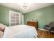 Bedroom with hardwood floors, natural light, closet and stylish dresser, creating a comfortable and organized space at 6911 N Tuxedo St, Indianapolis, IN 46220