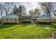 Charming brick home with a well-manicured lawn and beautiful landscaping at 6911 N Tuxedo St, Indianapolis, IN 46220