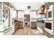 Bright kitchen with stainless steel appliances, two-tone cabinets and opens to dining area with decorative wallpaper at 6911 N Tuxedo St, Indianapolis, IN 46220