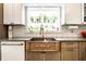 Close up of the kitchen sink with unique fixtures, lots of light and plants at 6911 N Tuxedo St, Indianapolis, IN 46220