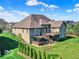 Exterior view of the home featuring a deck, pergola, and lush green lawn at 7128 Trail Ridge Ln, Indianapolis, IN 46259