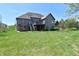 Large backyard with lush green grass, a patio, and a view of the home's exterior at 7128 Trail Ridge Ln, Indianapolis, IN 46259