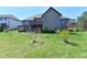 Spacious backyard featuring a two-story home with a deck, green lawn, and mature trees at 7128 Trail Ridge Ln, Indianapolis, IN 46259