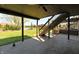 Spacious backyard with a covered patio and stairs to an upper deck overlooking a serene pond at 7128 Trail Ridge Ln, Indianapolis, IN 46259