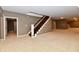 Finished basement features carpeted floors and a staircase at 7128 Trail Ridge Ln, Indianapolis, IN 46259