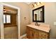 Bathroom featuring travertine flooring, a custom vanity with stone countertop, and a modern mirror at 7128 Trail Ridge Ln, Indianapolis, IN 46259