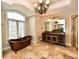 Bathroom showcases a clawfoot tub, travertine flooring, and a custom vanity with granite countertop at 7128 Trail Ridge Ln, Indianapolis, IN 46259