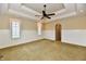 Spacious carpeted bedroom features wainscoting, a tray ceiling with lighting and a ceiling fan at 7128 Trail Ridge Ln, Indianapolis, IN 46259