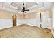 Spacious carpeted bedroom features wainscoting, a tray ceiling with lighting and a ceiling fan at 7128 Trail Ridge Ln, Indianapolis, IN 46259