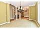 Elegant dining room featuring neutral carpeting, a chandelier, and classic architectural details at 7128 Trail Ridge Ln, Indianapolis, IN 46259