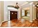 Elegant foyer with hardwood floors, a grand chandelier, and a view into adjacent living spaces at 7128 Trail Ridge Ln, Indianapolis, IN 46259