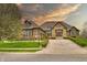 Beautiful single-story home featuring an arched entrance, brick accents, a driveway, and manicured landscaping at 7128 Trail Ridge Ln, Indianapolis, IN 46259