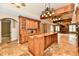 A kitchen with wooden cabinets, granite countertops, an island, and tiled floors adjoins a living area with a fireplace at 7128 Trail Ridge Ln, Indianapolis, IN 46259