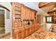 Wooden kitchen cabinets with glass inserts and granite countertops sit beside a living area with a fireplace at 7128 Trail Ridge Ln, Indianapolis, IN 46259
