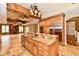 A kitchen with wood cabinets, granite countertops, stainless appliances, and tile flooring adjoins a living area with a fireplace at 7128 Trail Ridge Ln, Indianapolis, IN 46259