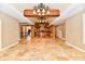 Open kitchen and dining area features travertine floors, a beamed ceiling, and custom wood cabinets at 7128 Trail Ridge Ln, Indianapolis, IN 46259