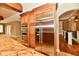 A kitchen with wooden cabinets, granite countertops, and stainless steel appliances sits beside a staircase at 7128 Trail Ridge Ln, Indianapolis, IN 46259
