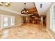 Open concept living area boasts tiled floors, a fireplace, a wood beam with chandeliers, and plenty of natural light at 7128 Trail Ridge Ln, Indianapolis, IN 46259