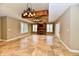 Living area features tiled flooring, white shutters, a fireplace, and ornate chandeliers hanging from a dark wooden beam at 7128 Trail Ridge Ln, Indianapolis, IN 46259
