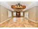 A bright living room showcases tiled flooring, white shutters, a fireplace, and ornate chandeliers hanging from a wood beam at 7128 Trail Ridge Ln, Indianapolis, IN 46259