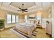 Staged main bedroom with tray ceiling lighting, wainscoting, and two windows overlooking the property at 7128 Trail Ridge Ln, Indianapolis, IN 46259