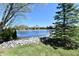 Scenic pond view with lush greenery and elegant homes in the background under a bright blue sky at 7128 Trail Ridge Ln, Indianapolis, IN 46259